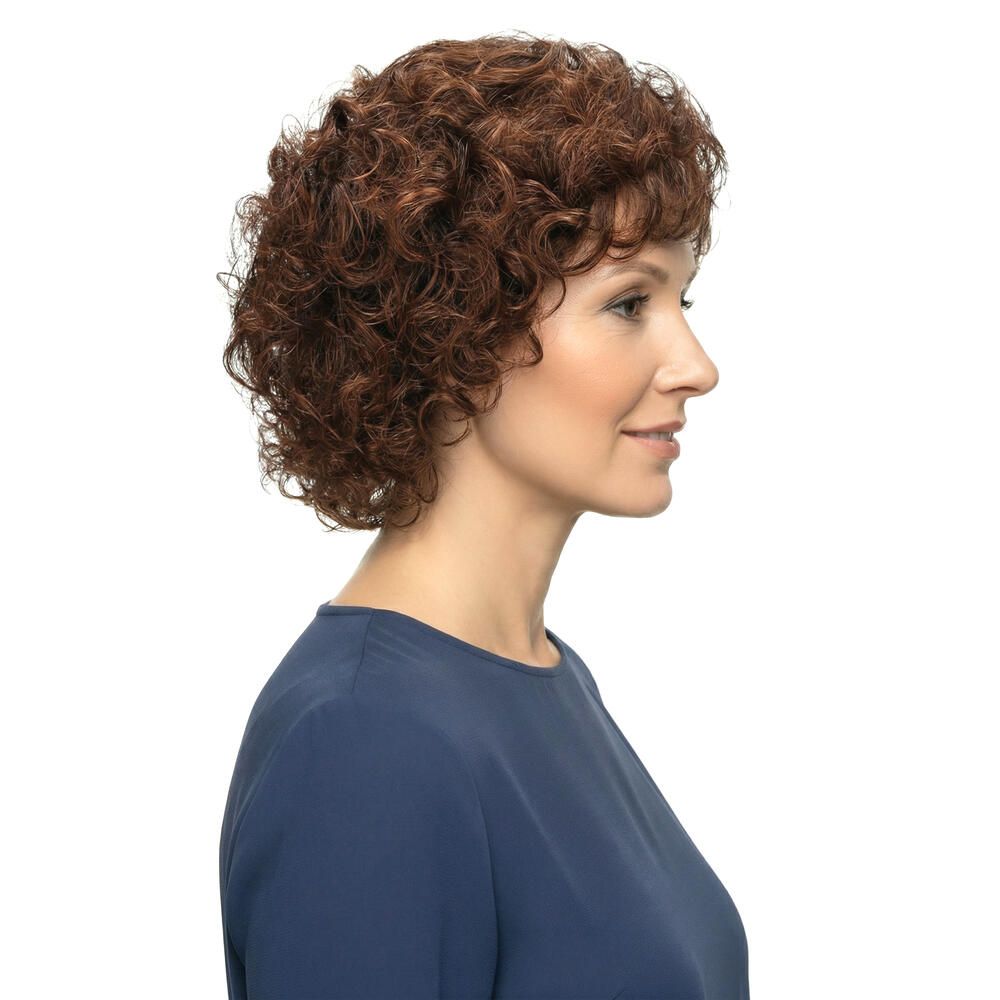 Frau mit brauner, lockiger Perücke. Seitliche Ansicht. Die Perücke bedeckt den Kopf und hat kurze Locken. Die Frau trägt ein blaues Oberteil.