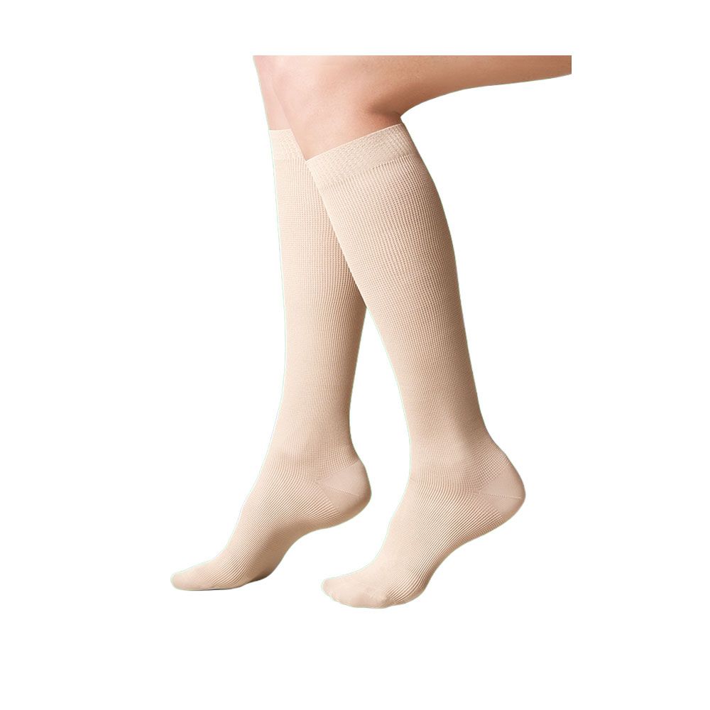 Beige Kniestrümpfe. Geripptes Material. Zehen- und Fersenbereich. Auf weißem Hintergrund. Füße und Unterschenkel.