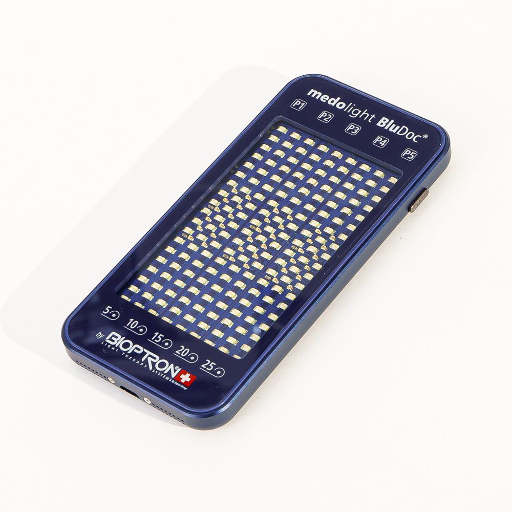 Blaues medolight BluDoc-Gerät mit weißem Licht. Rechteckig, mit LEDs. Zeigt Zeitangaben und Bioptron-Logo.