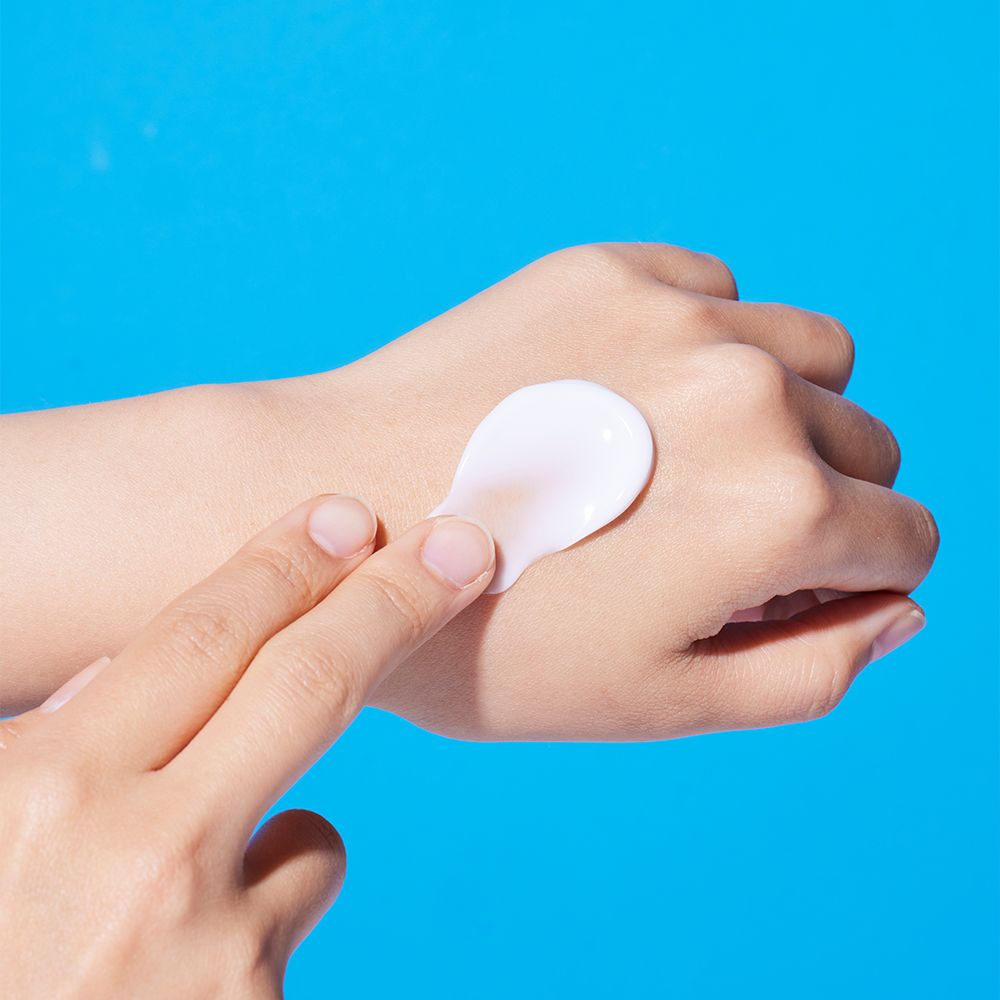 Creme wird auf eine Hand aufgetragen, um die Hautfeuchtigkeit zu zeigen.