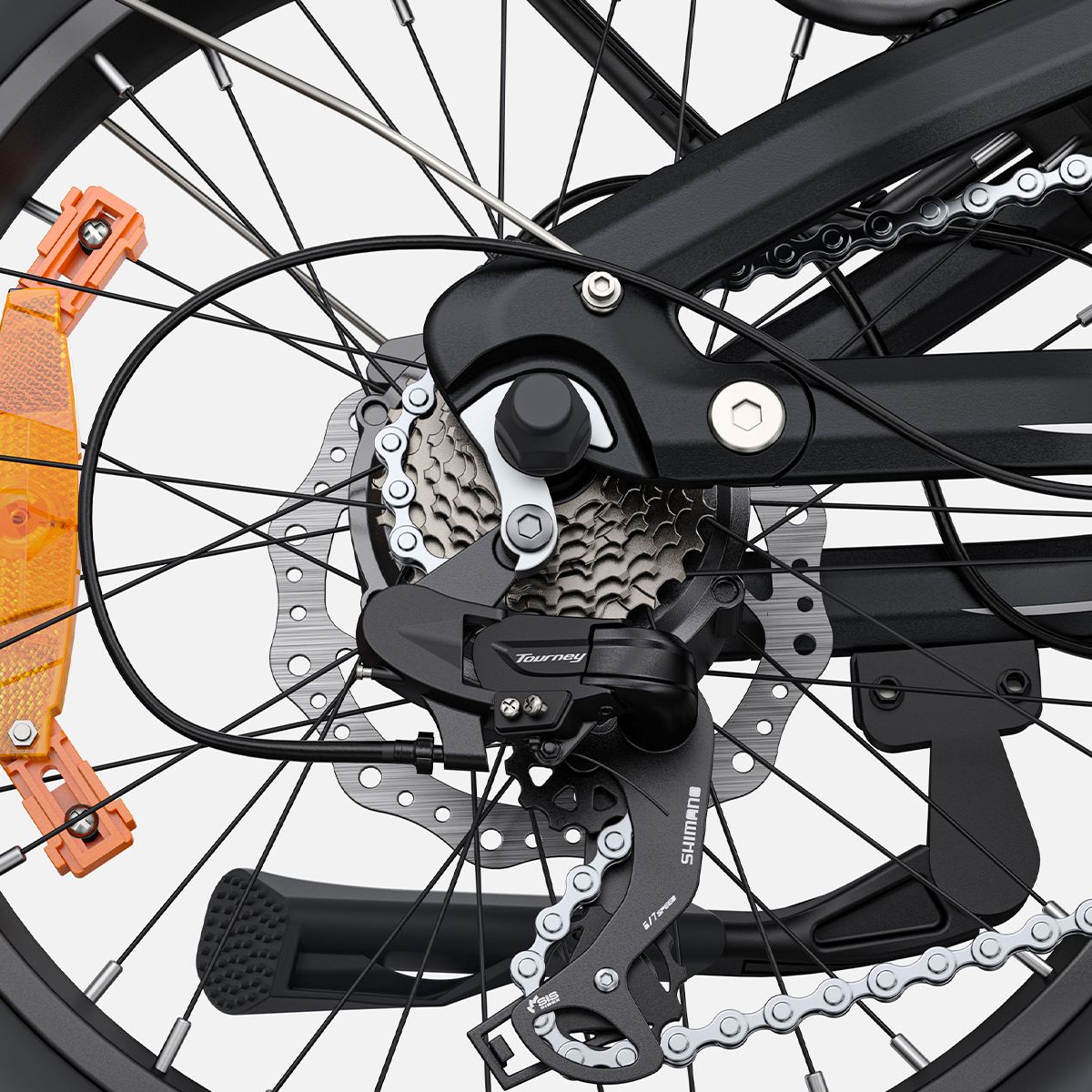 Nahaufnahme des Hinterrads eines Elektrofahrrads. Schwarze Komponenten, Kette und Zahnräder.