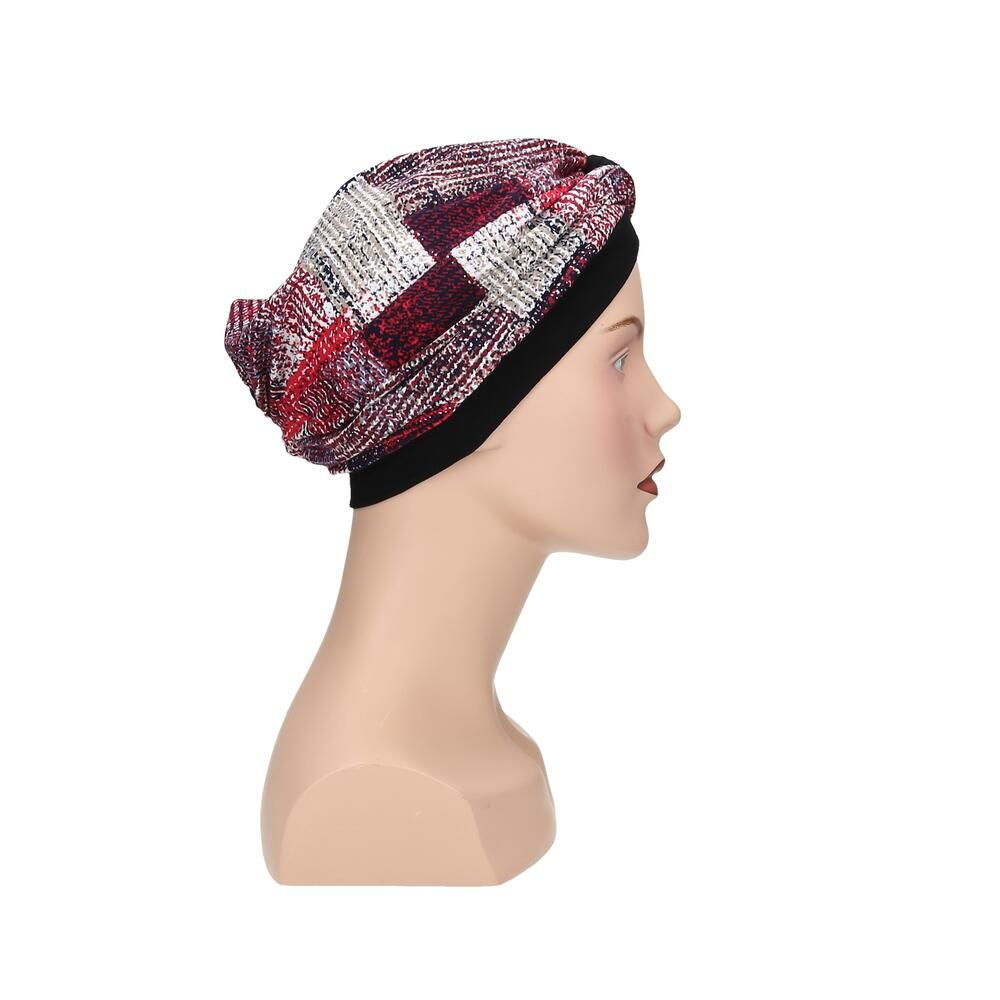 Turban mit mehrfarbigem Muster auf einem Schaufensterpuppenkopf. Schwarzes Stirnband. Seitenansicht.