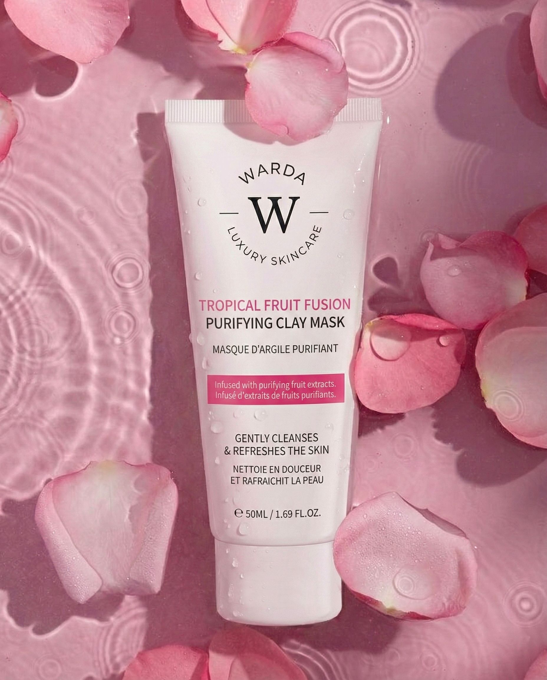 Warda Luxury Skincare Tropical Fruit Fusion Reinigende Tonmaske. Weiße Tube mit rosa Text. Umgeben von rosa Blütenblättern.