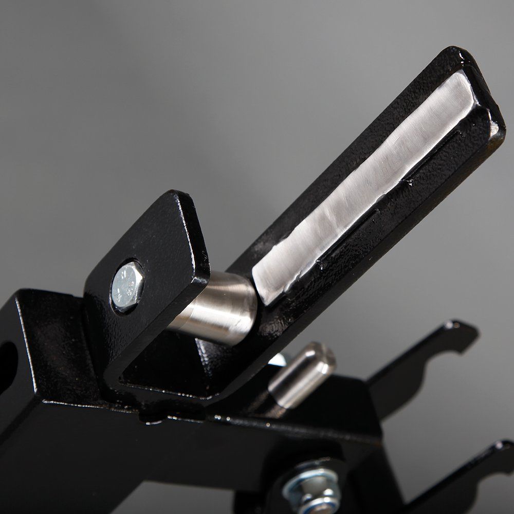 Nahaufnahme eines schwarzen Metallteils mit einem Bolzen. Grauer Hintergrund.