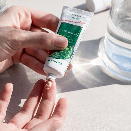 Person hält Tube mit Produkt. Produkt wird auf Finger aufgetragen. Aufschrift: KORRES, Watermelon, Maske. Grün-weißes Etikett.