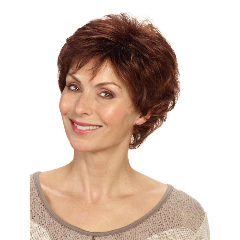 Kurzhaarperücke, rotbraun, gewellt. Frau mit Perücke, lächelnd. Beige Oberteil. Frontalansicht.