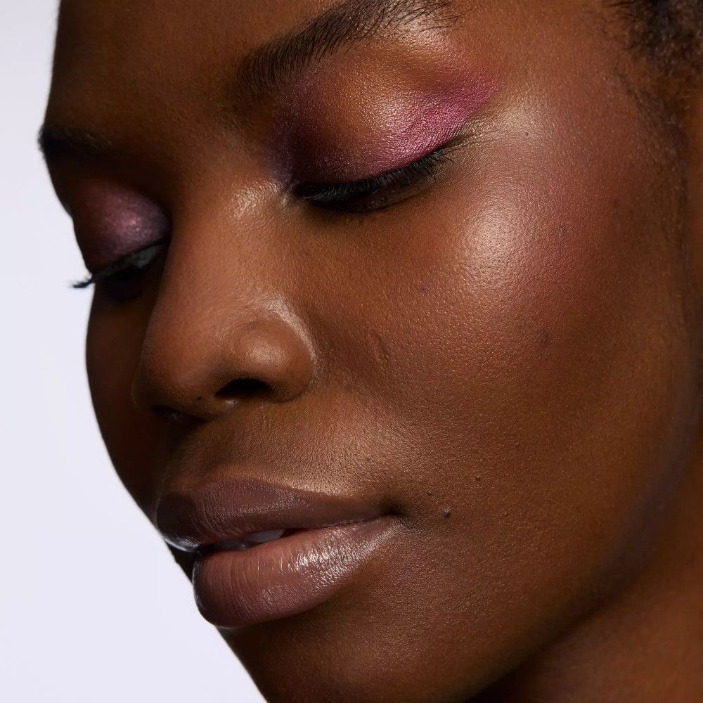 Nahaufnahme einer Frau mit rosafarbenem Lidschatten. Geschlossene Augen.