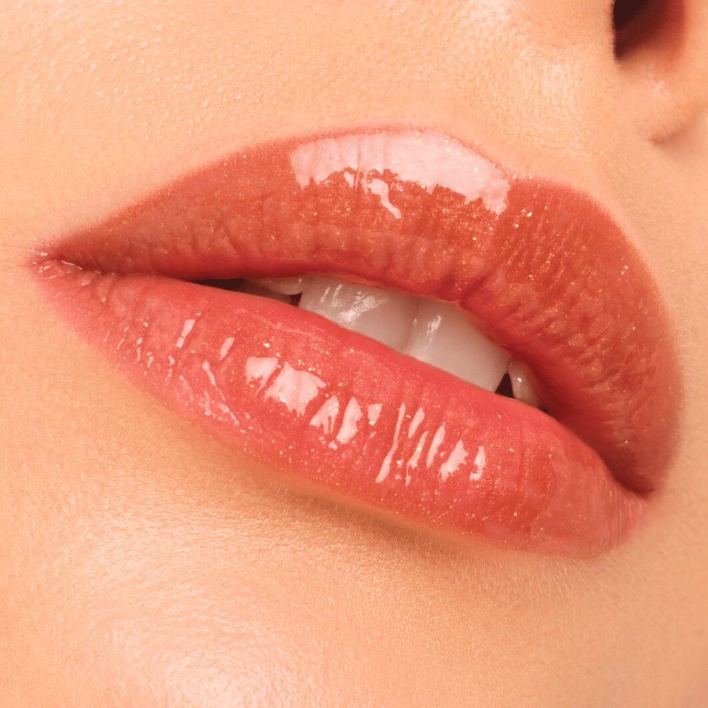 Nahaufnahme von Lippen mit glänzendem Gloss. Lippen in einem bräunlichen Farbton. Glänzende Textur.