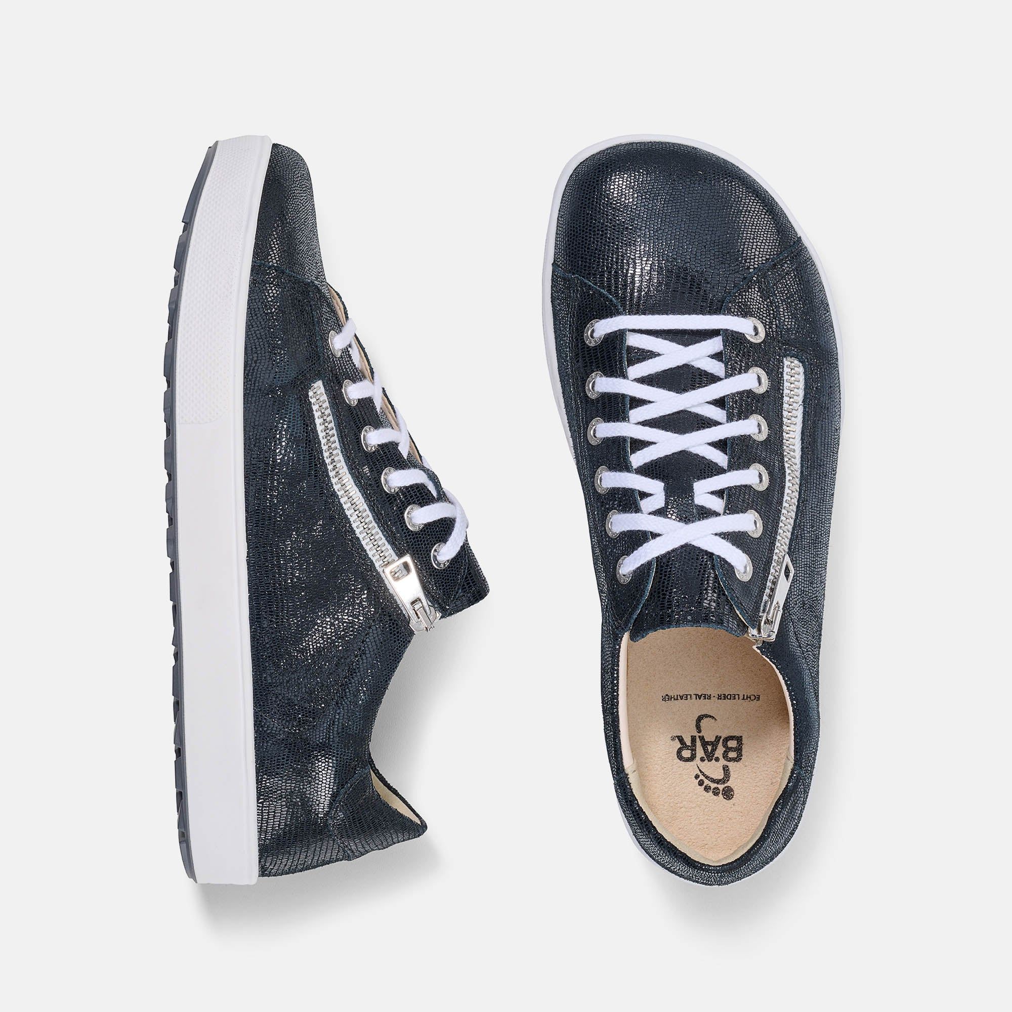 Zwei dunkelblaue Schnürschuhe mit weißer Sohle. Reißverschluss und weiße Schnürsenkel. Blick von oben.