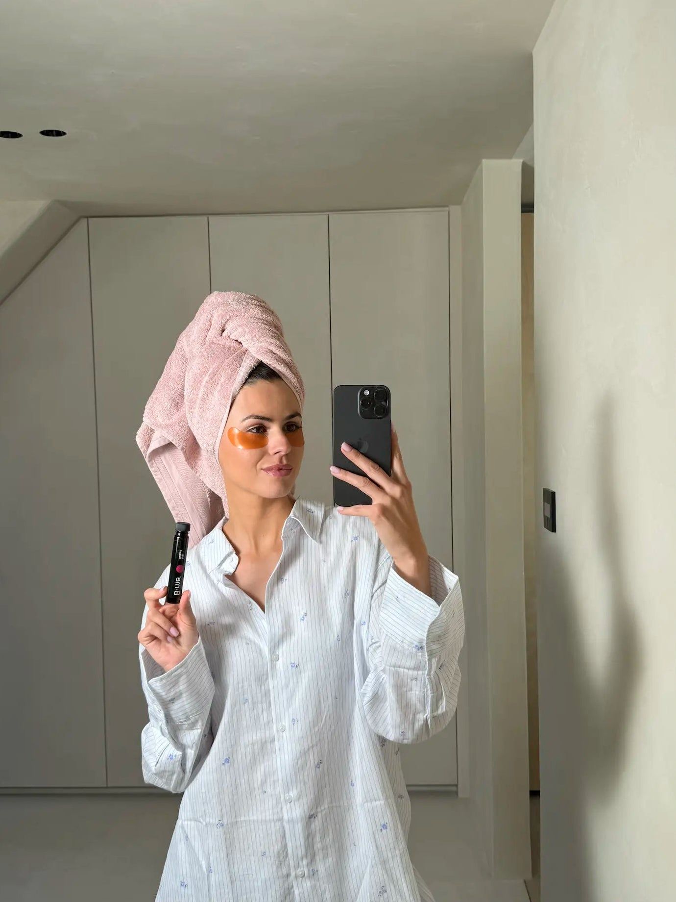 Frau mit Handtuch auf dem Kopf hält B.me® Anti-Oxidant. Sie macht ein Selfie. Das Produkt ist in einer Ampulle.