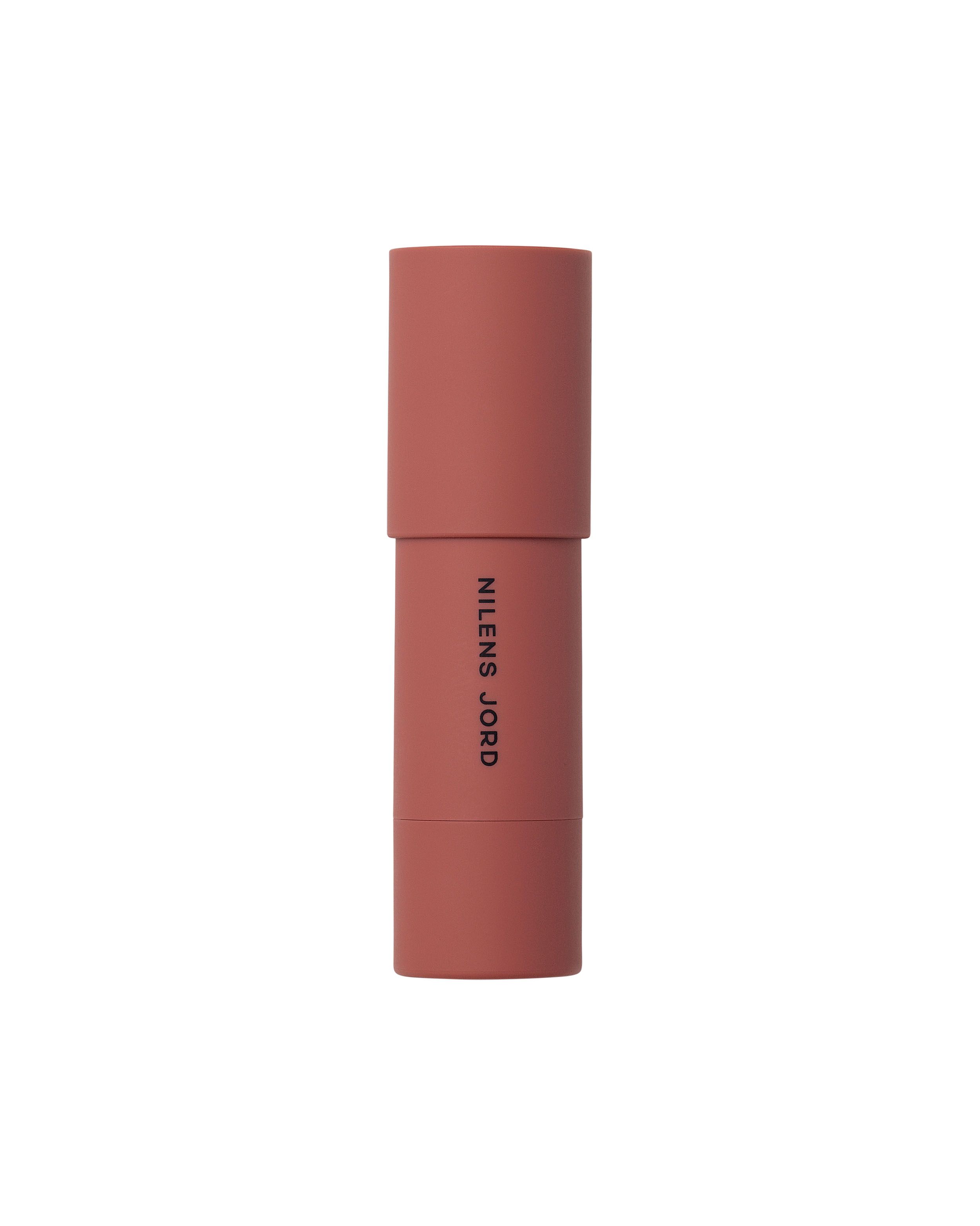 Nilens Jord Cheeks & Lips Stick, rosafarbener Behälter mit aufgestecktem Deckel.