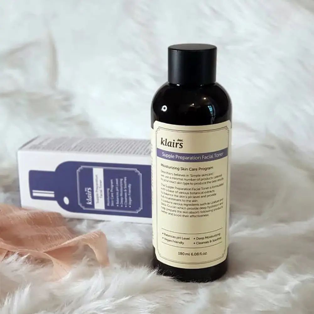 Klairs Supple Preparation Facial Toner Flasche. Braune Flasche mit schwarzem Deckel. Etikett mit Produktinformationen. Hintergrund: Stoff.