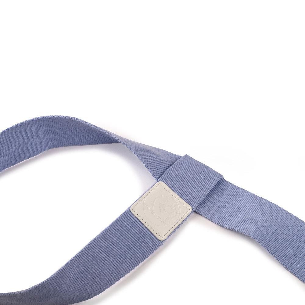 Detailansicht eines hellblauen Yogamatten-Tragegurts mit einer quadratischen Lederapplikation und Stoffschlaufe.