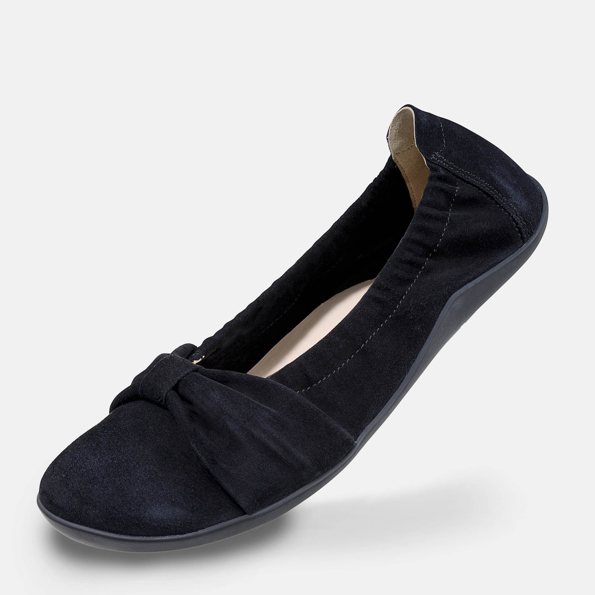 Schwarzer Ballerina. Weiches Obermaterial, Schleife vorne. Flache Sohle. Schuh leicht schräg.