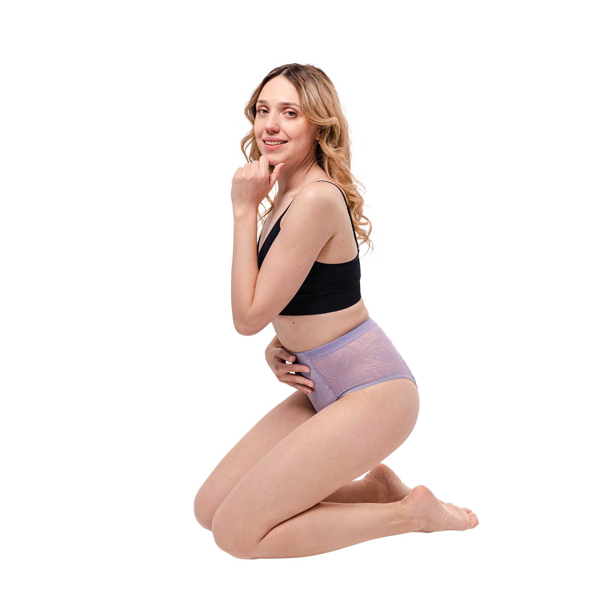 Frau kniet, trägt hellviolette Periodenunterwäsche mit Spitze, High Waist. Hält Hand am Bauch.