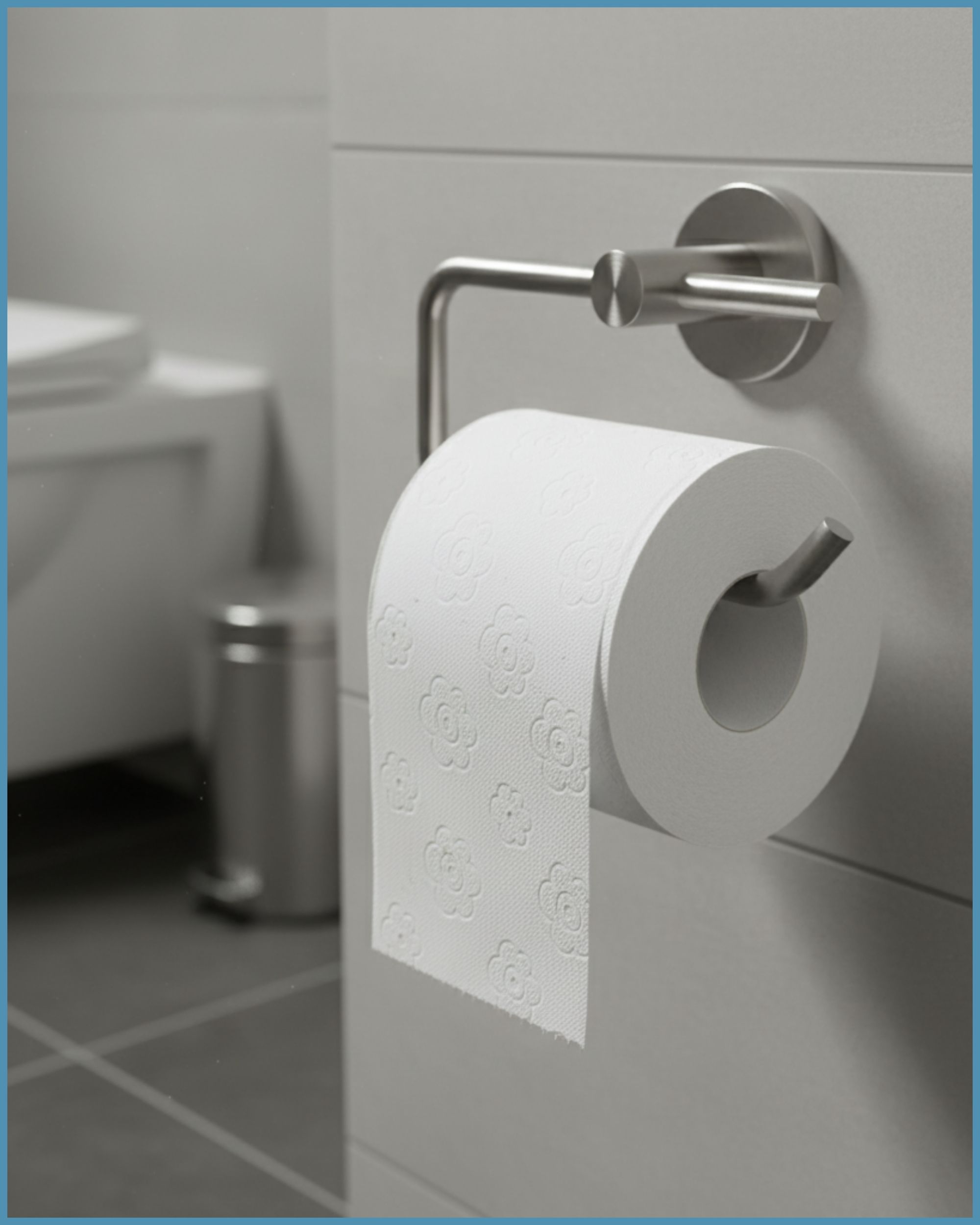 Toilettenpapierrolle in Halterung. Weißes Papier mit floralem Muster. Badezimmer-Kontext. Metallhalterung an weißer Wand.