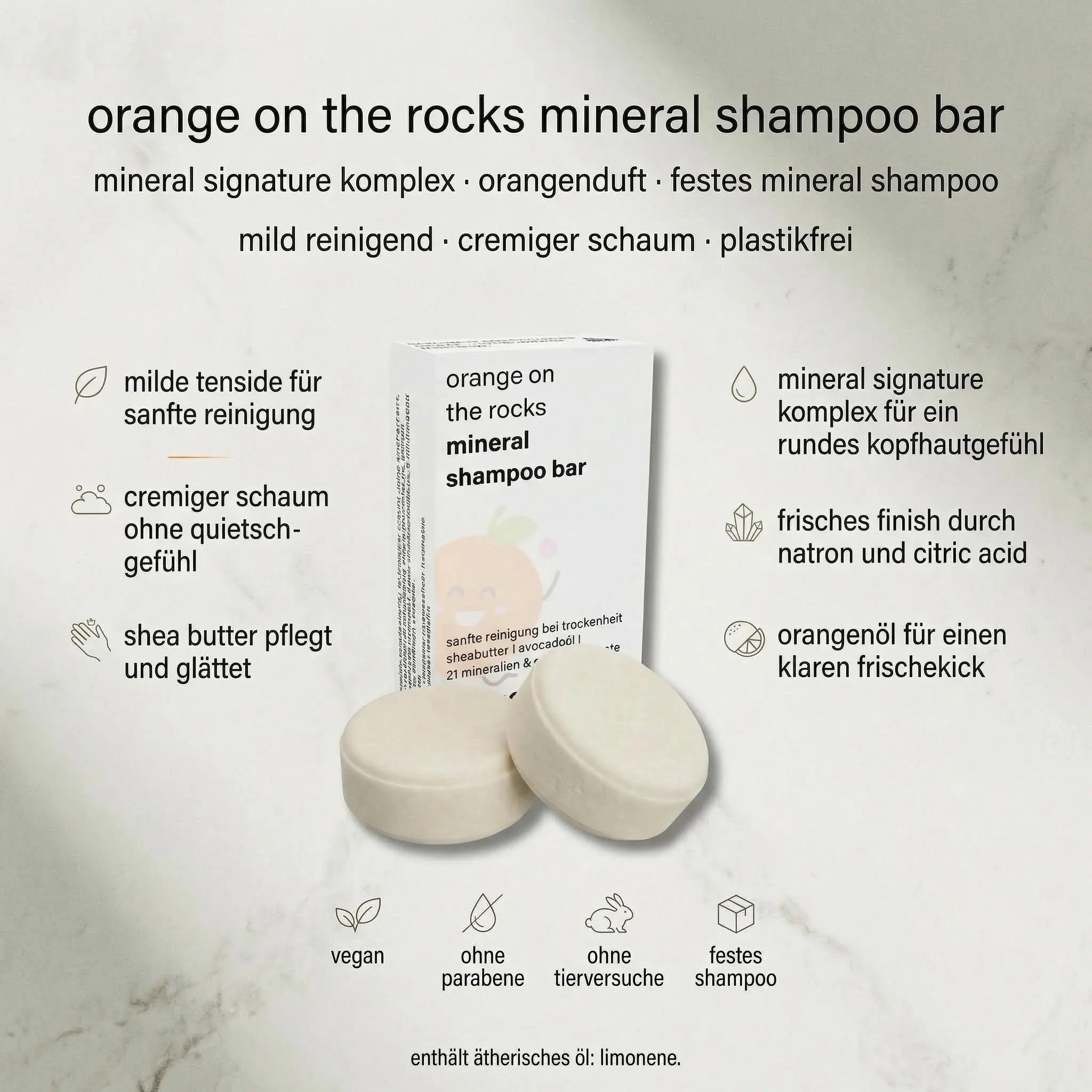 Zwei runde, helle Shampoo-Bars neben der Verpackung. Aufschrift: orange on the rocks mineral shampoo bar. Vegan, ohne Parabene, ohne Tierversuche.