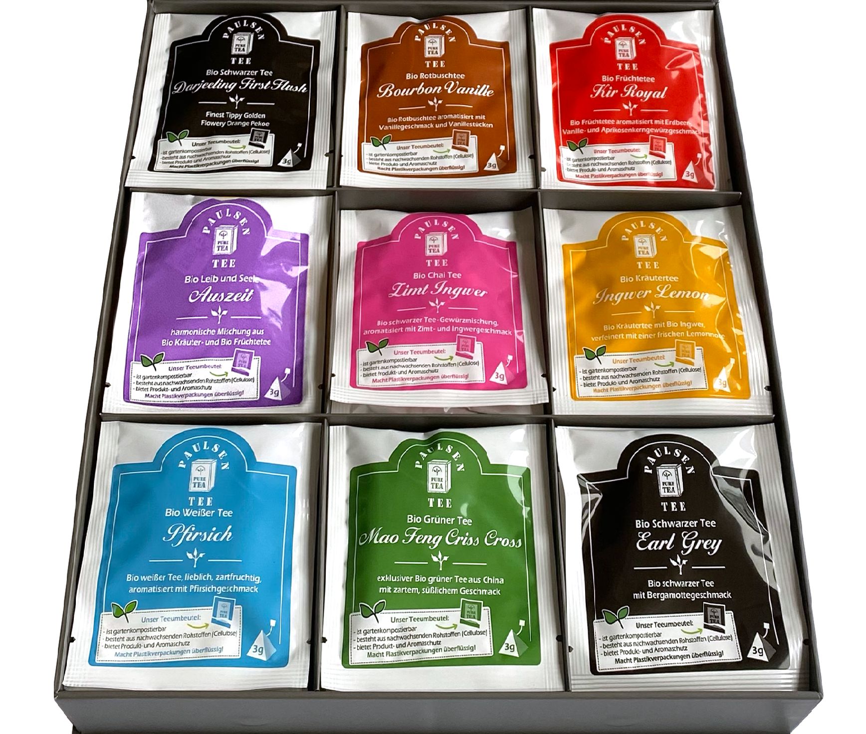 Geschenkbox mit Teebeuteln. Neun Pyramidenbeutel mit verschiedenen Teesorten in einer Schachtel. Verschiedene Farben und Aufschriften.