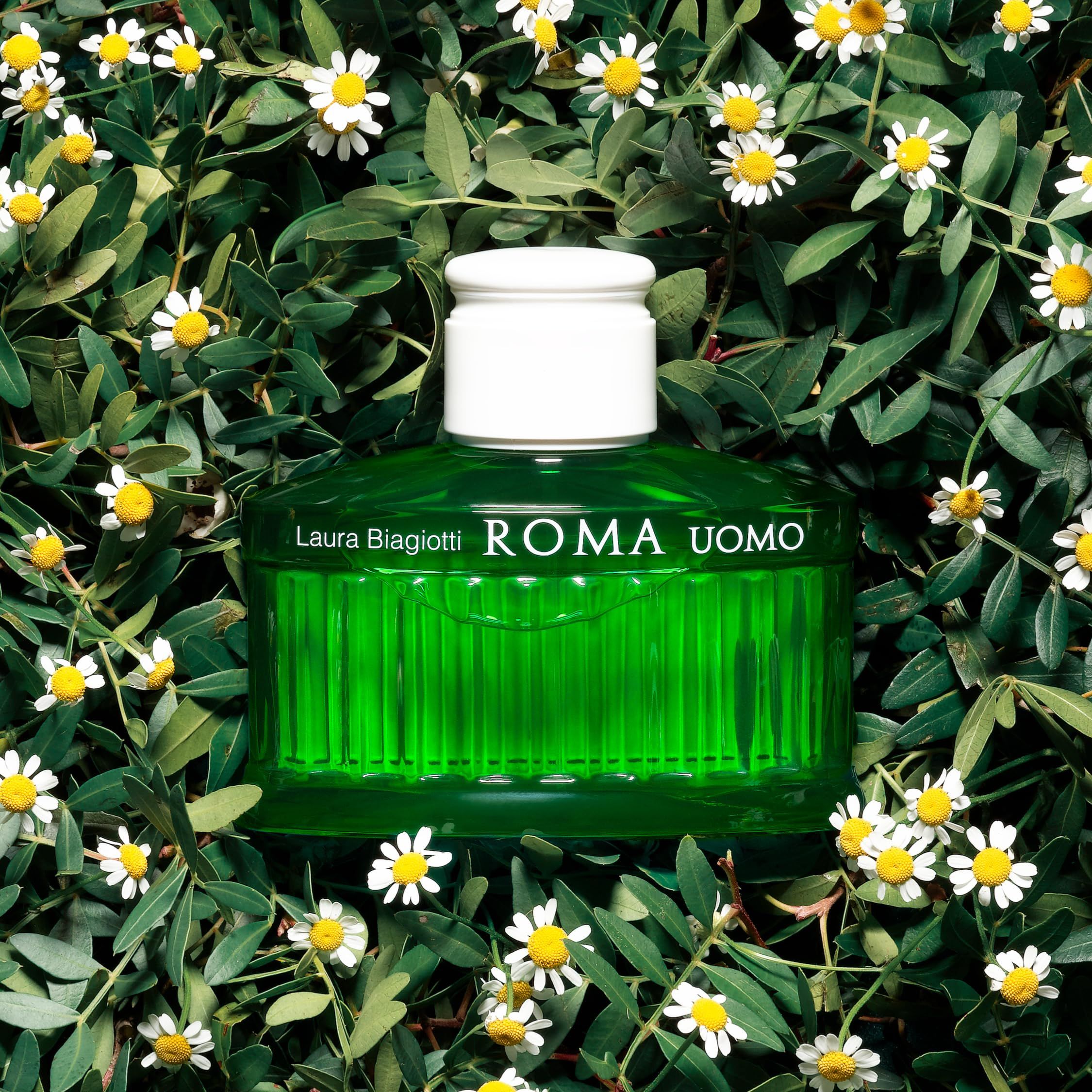 Grüne Flasche auf Blättern und Blüten. Aufschrift: Laura Biagiotti, ROMA UOMO.
