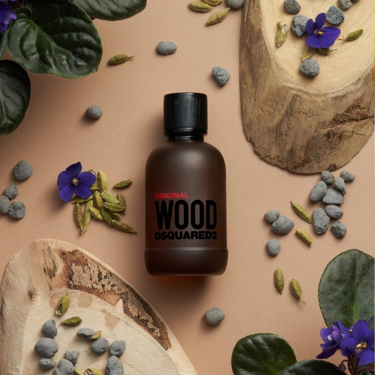 Dsquared2 Wood Original Eau de Parfum Flakon mit schwarzem Verschluss, umgeben von Naturmaterialien.
