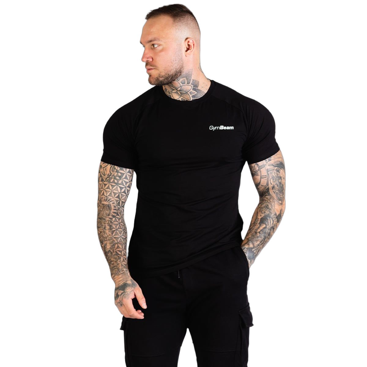 Mann in schwarzem GymBeam T-Shirt und Cargohosen, steht seitlich, Blick nach links.