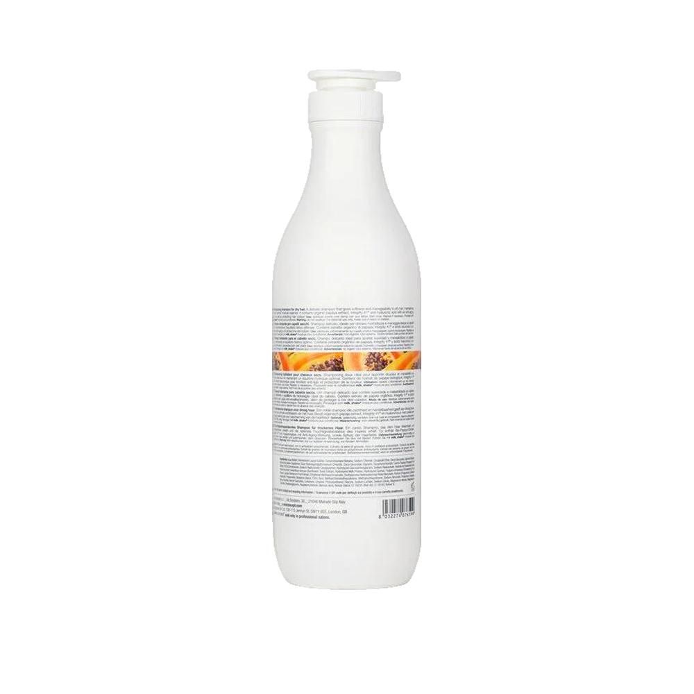 Rückseite einer weißen Flasche mit Pumpe. Text: milk_shake, moisture plus shampoo. Orangefarbener Streifen mit Papaya-Abbildung. Textinformationen.
