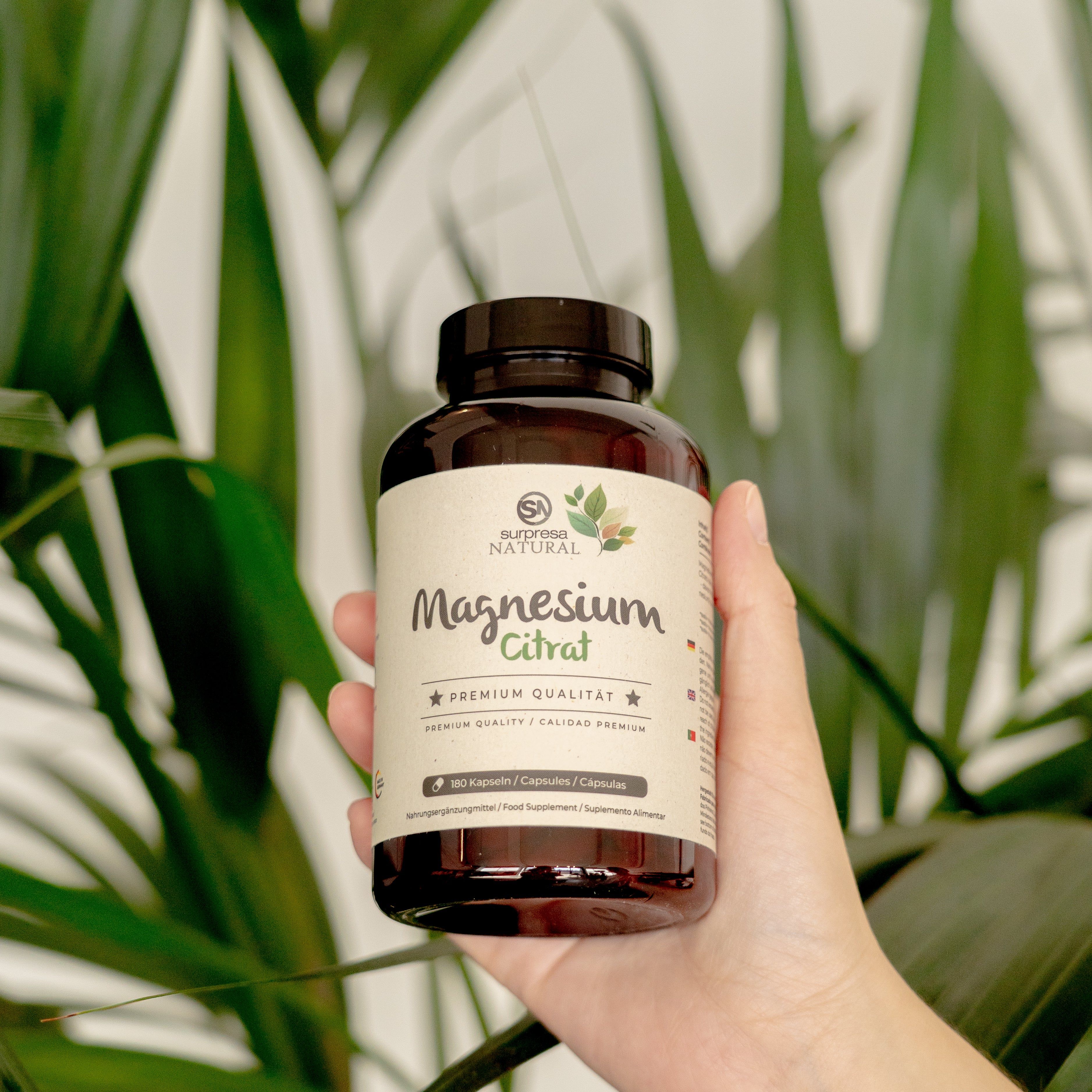 Braune Flasche mit Etikett, gehalten von einer Hand. Aufschrift: Surpresa Natural Magnesium Citrat. 180 Kapseln.