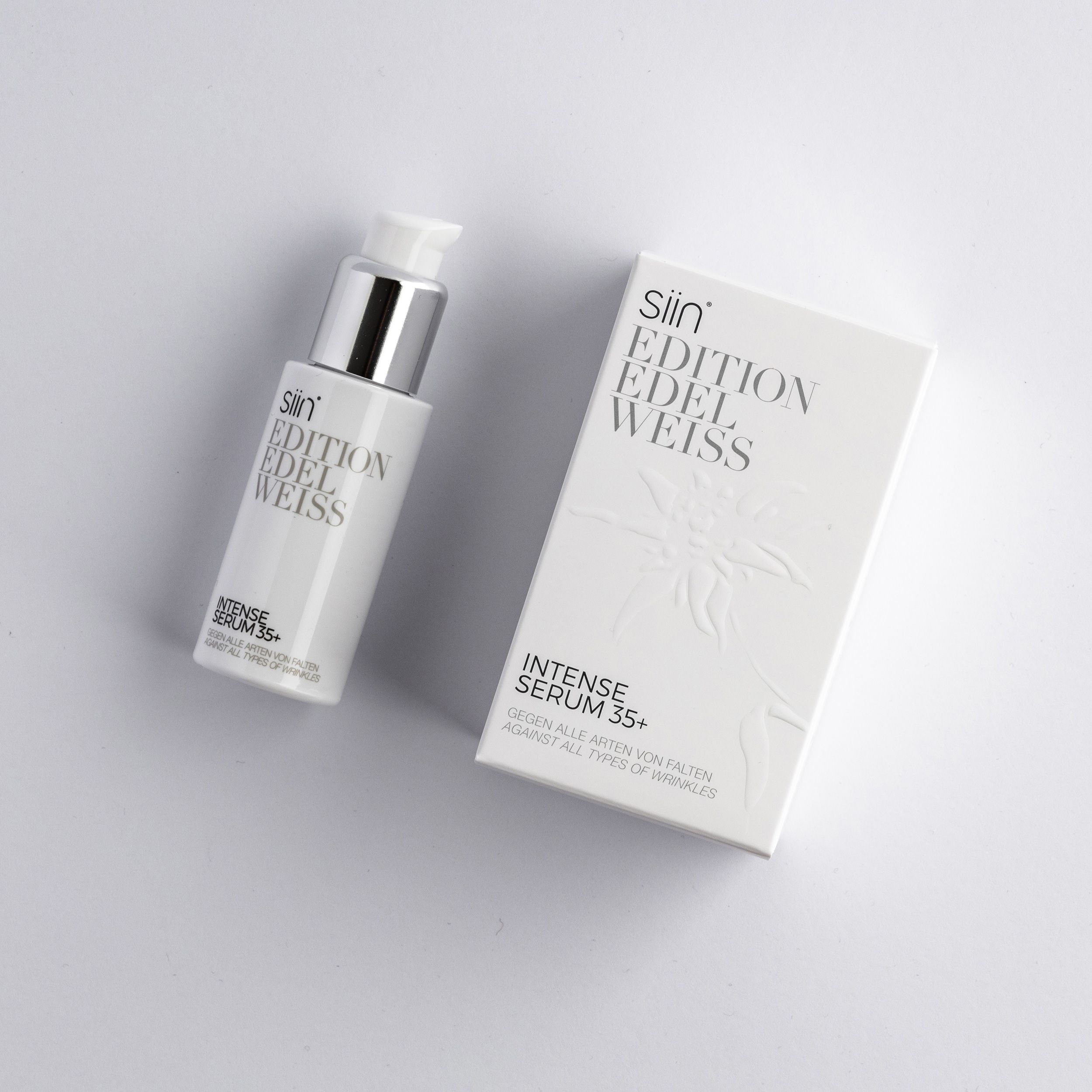 Weiße Flasche und Schachtel mit Produktnamen und Text. Flasche mit silbernem Pumpkopf. Schachtel mit geprägtem Edelweiß-Design.
