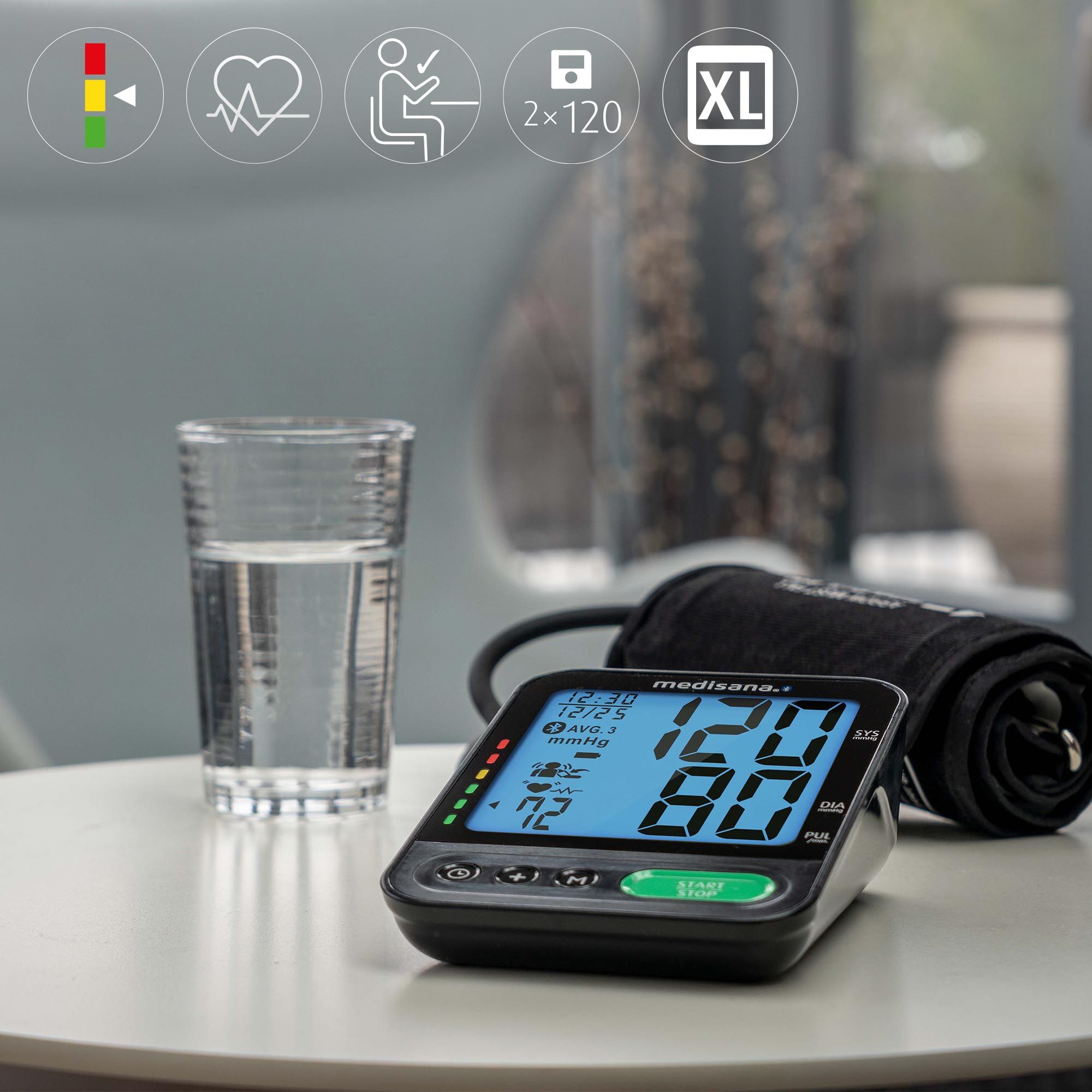 Bloeddrukmeter met manchet op tafel. Apparaat toont meetwaarden. Glas water ernaast. Symbolen voor hart, zithouding, XL.