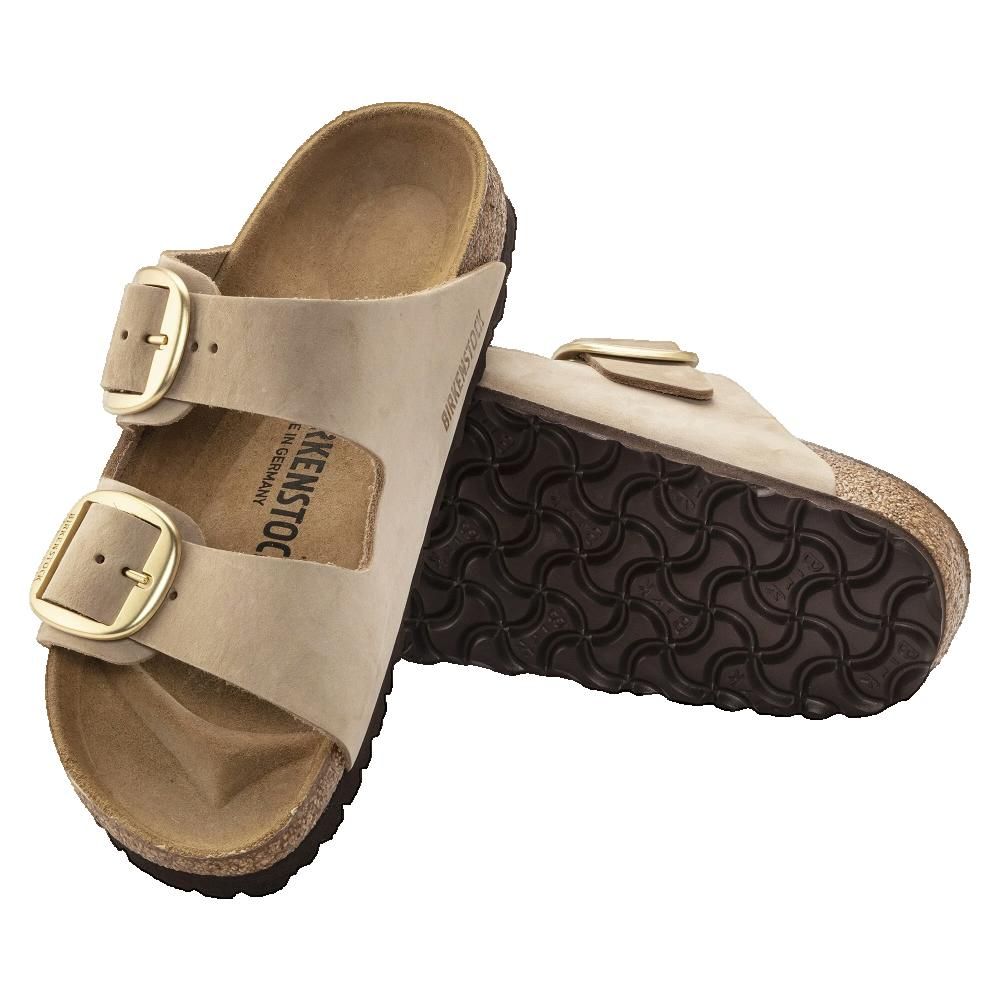 Sandali con due cinturini e grandi fibbie. Pelle beige, plantare in sughero, fibbie dorate. Marchio visibile.