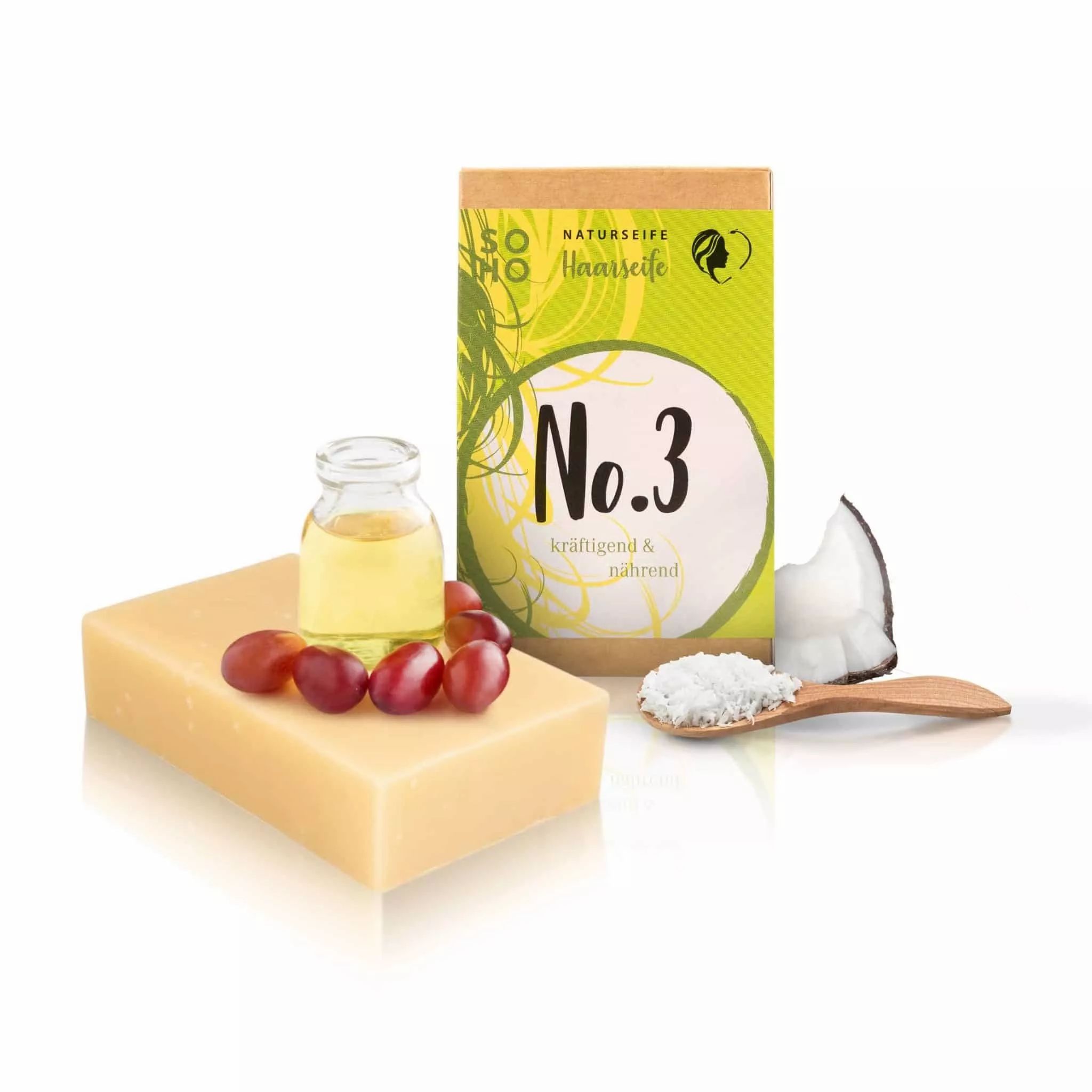 Seife und Verpackung. Seife mit Trauben und Öl. Verpackung mit Text: No.3, Naturseife. Kokosnuss und Löffel mit Pulver.