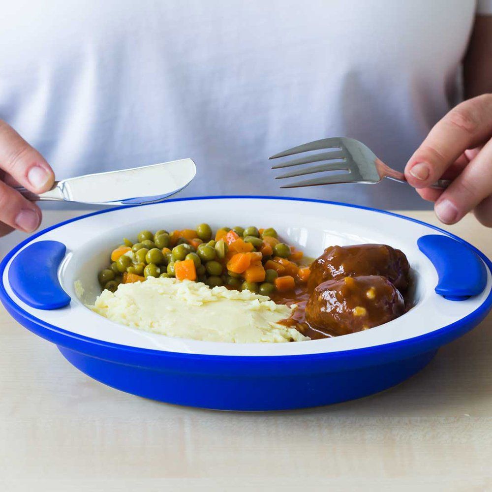 Blauer Teller mit Essen, gehalten von Händen mit Messer und Gabel.