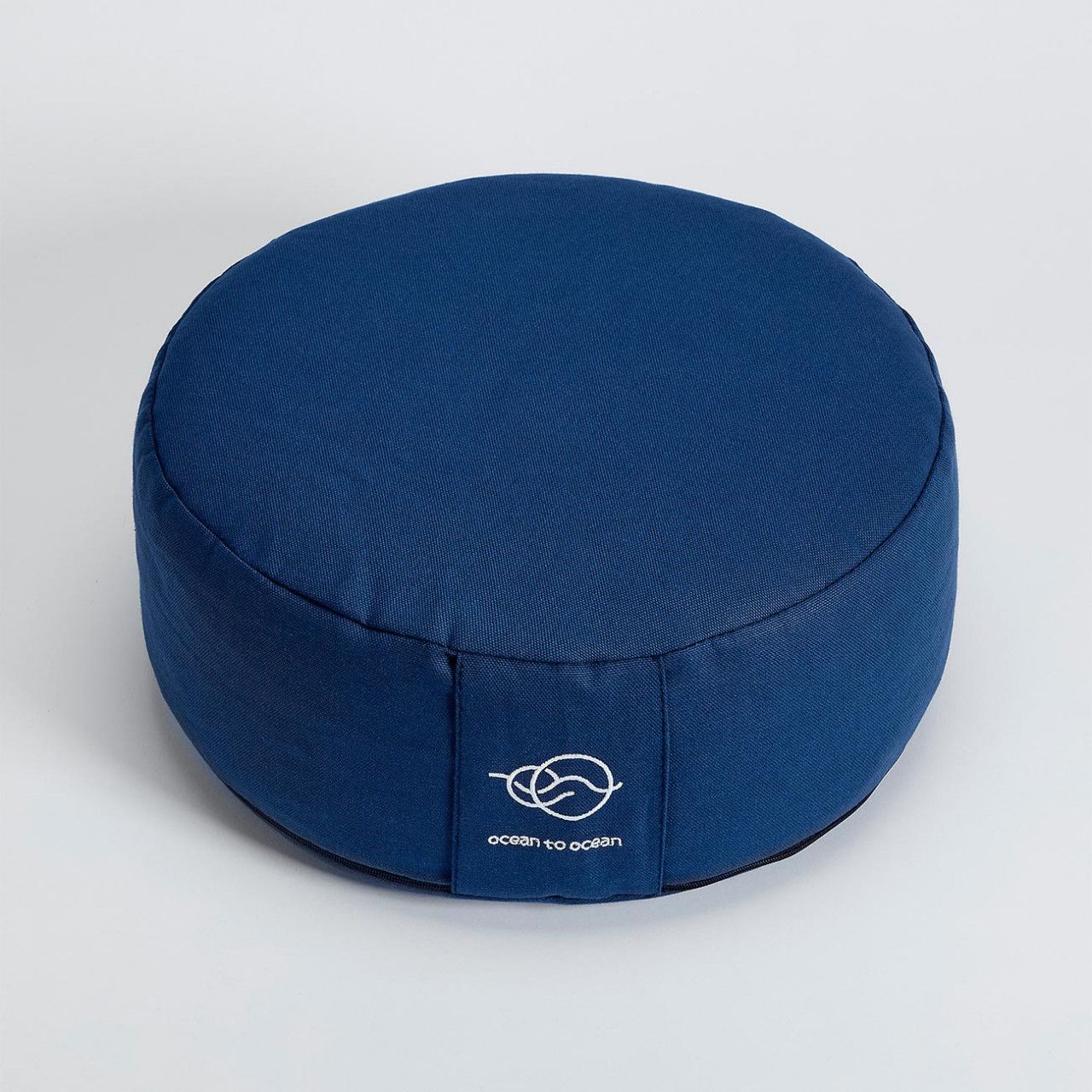 Rundes, blaues Meditationskissen mit weißem Logo "ocean to ocean".