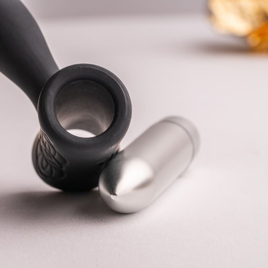 Schwarzes Wellness-Produkt und silberfarbener Aufsatz. Sichtbar: Produkt, Aufsatz.