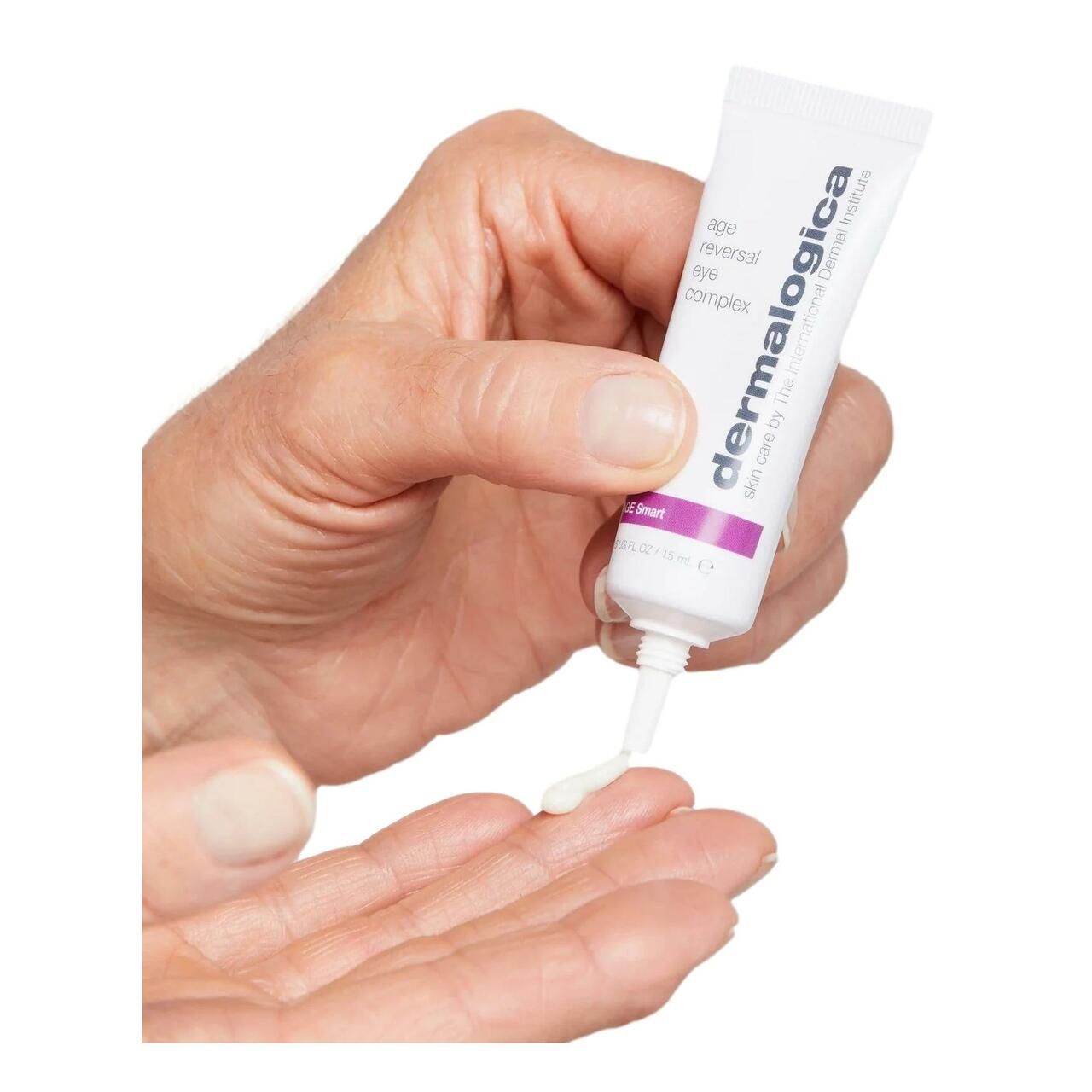 Hand gibt Creme aus Tube auf Handfläche. Aufschrift: Dermalogica, Age Smart, Age Reversal Eye Complex.