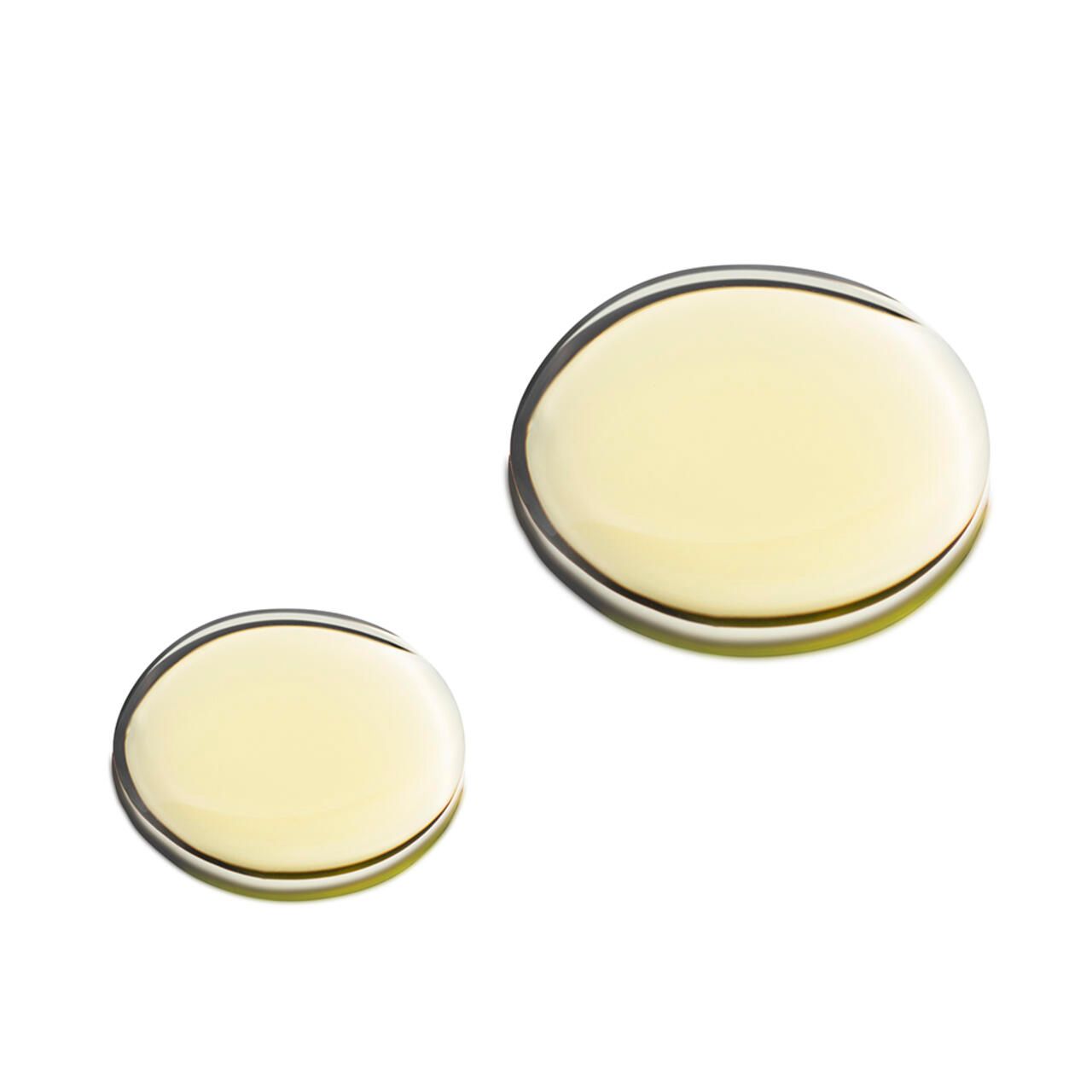 Zwei ovale Tropfen Öl. Hellgelb, auf weißem Hintergrund. Runde Form, glatte Oberfläche. Nahaufnahme.