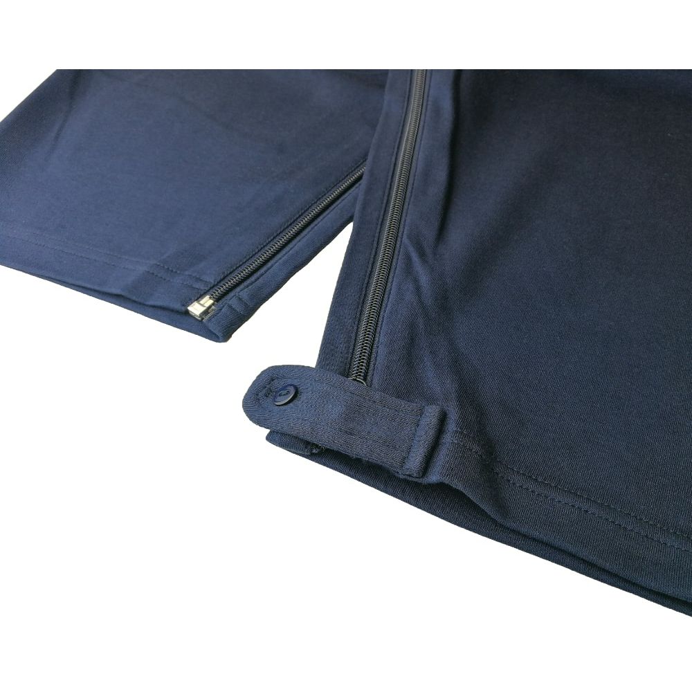 Detailansicht des blauen Pflegeoveralls. Reißverschluss an Bein und Knopfverschluss am Beinende.