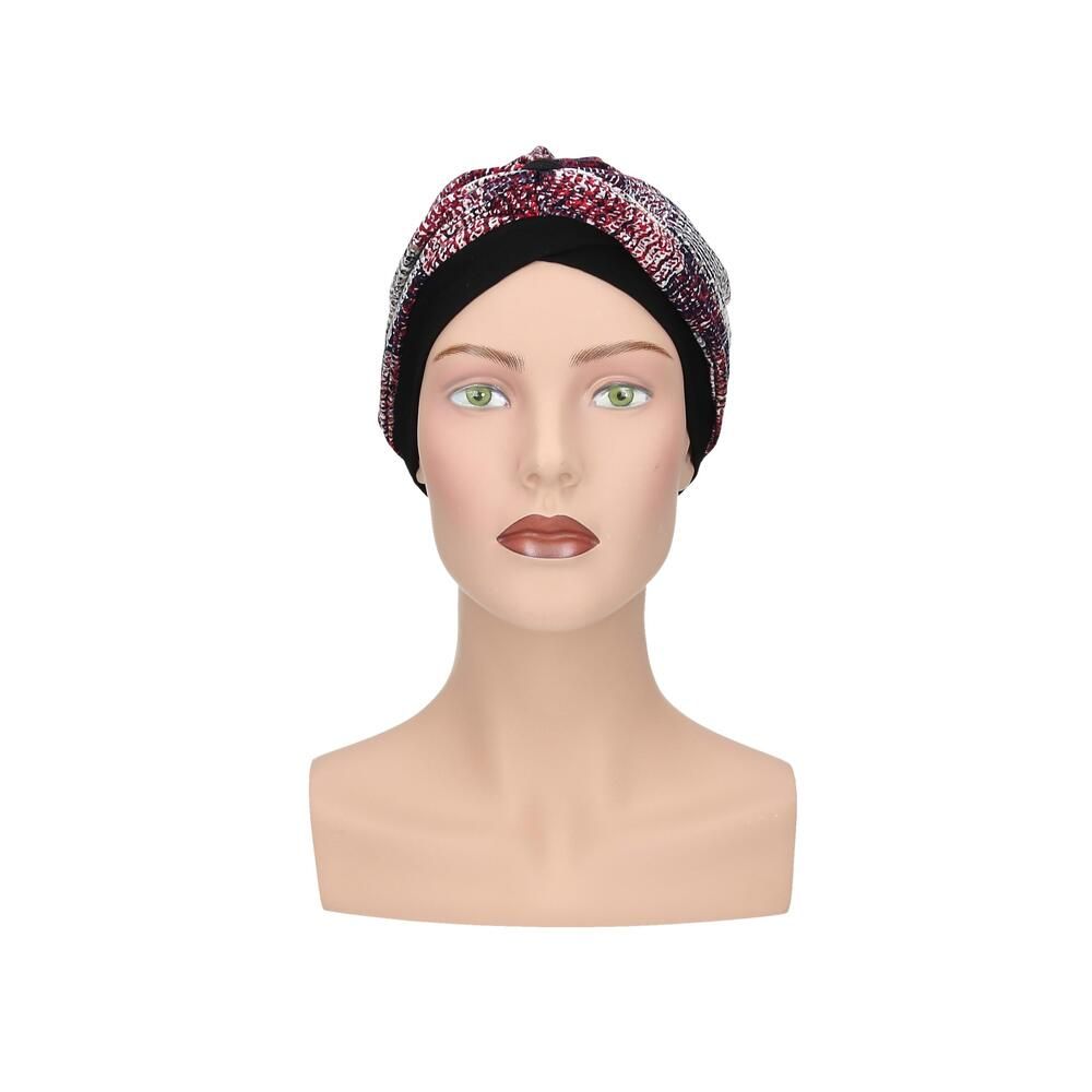 Turban mit mehrfarbigem Muster auf schwarzem Untergrund, auf einer Schaufensterpuppe.