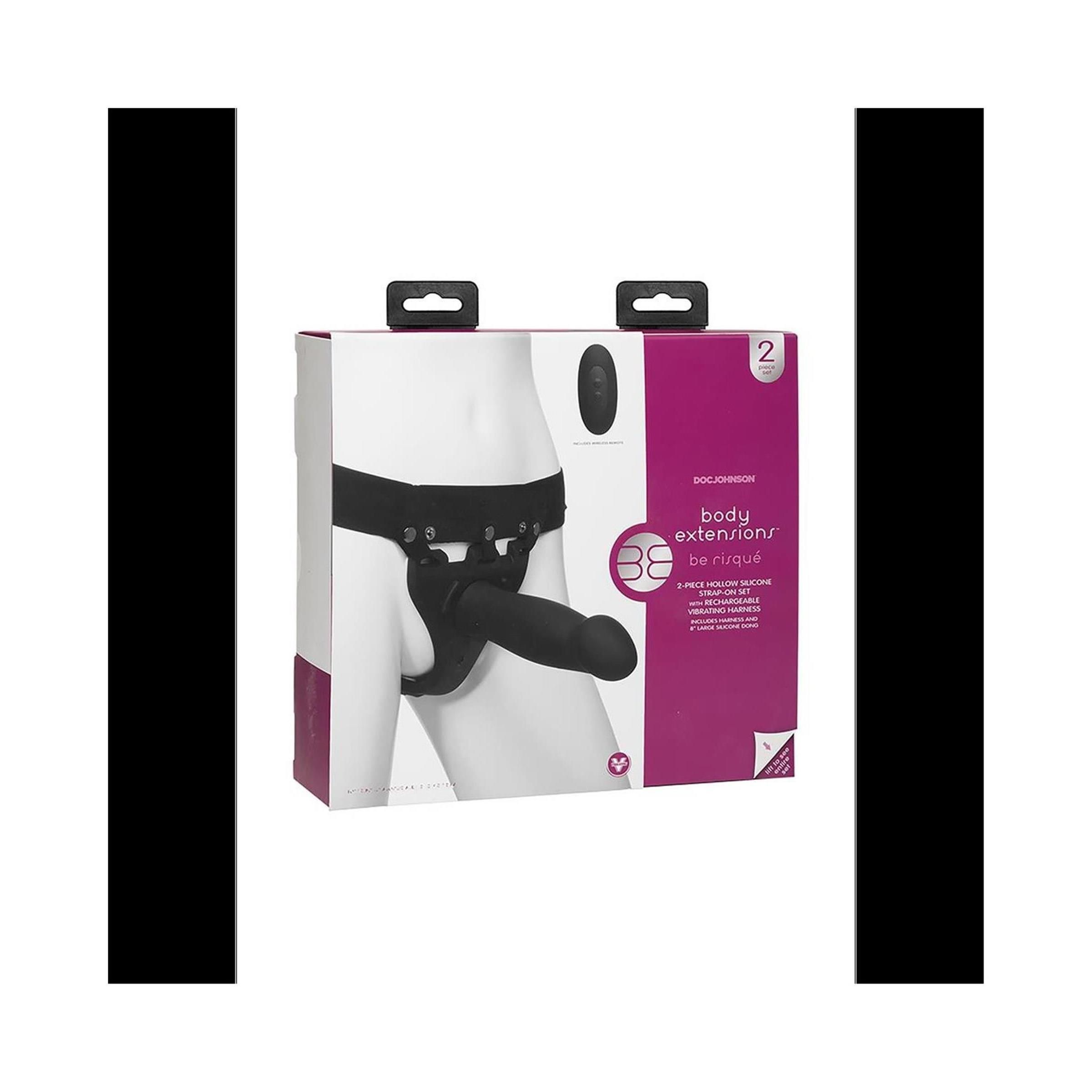 Verpackung mit schwarzem Harness und Dildo. Aufdruck: Body Extensions. Zwei Tragegriffe oben.