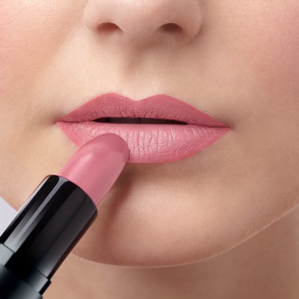 Person trägt rosa Lippenstift auf den Lippen auf. Schwarzer Lippenstift.