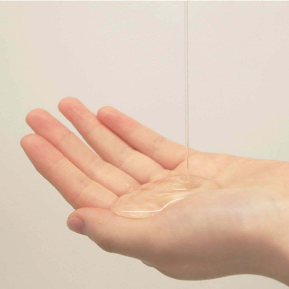 Klare Flüssigkeit wird auf eine Hand gegossen. Die Hand ist leicht geöffnet, die Flüssigkeit bildet eine Pfütze.