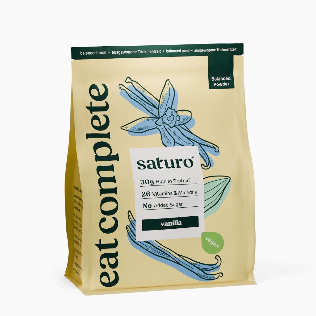 Beutel mit Saturo Trinkmahlzeit Vanille. Aufdruck: 30g Protein, 26 Vitamine & Mineralien, vegan. Abbildung von Vanilleblüten.