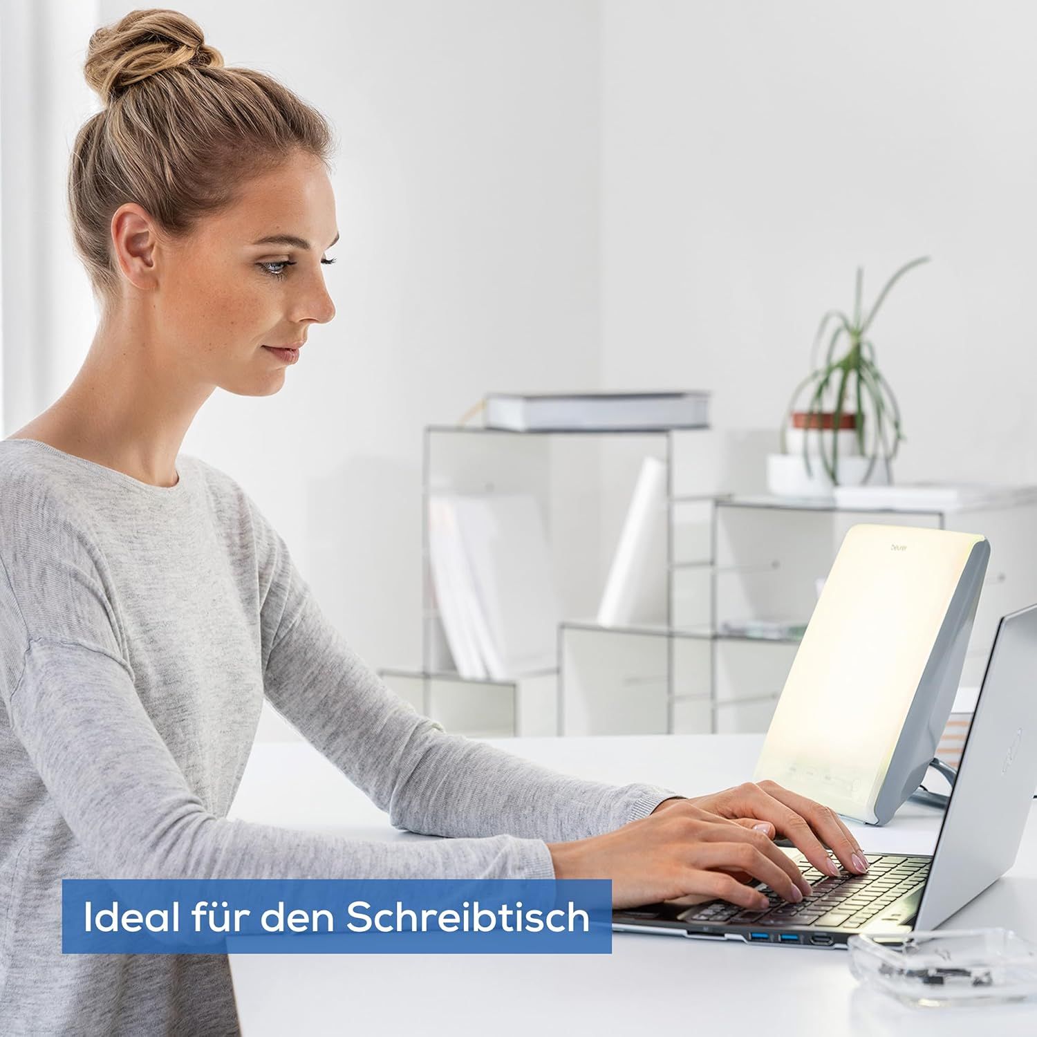 Eine Frau arbeitet an einem Laptop. Tageslichtlampe auf dem Tisch. Text: Ideal für den Schreibtisch.