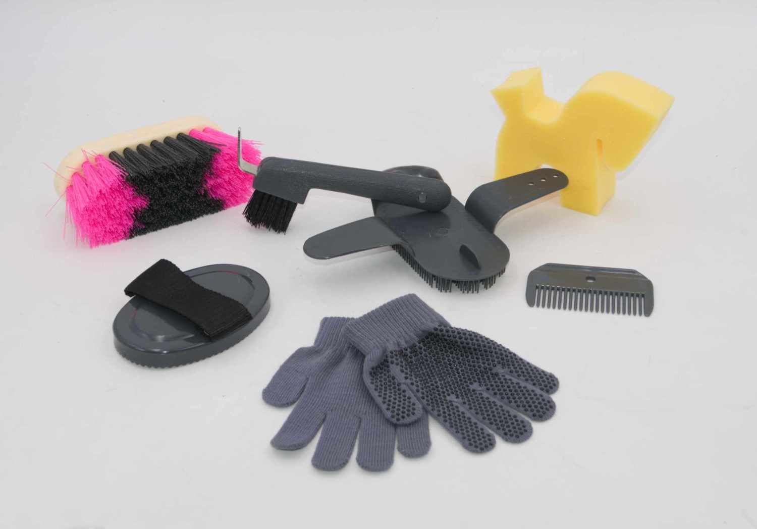 AMKA Putzbox LINA. Die Box ist nicht abgebildet. Enthalten sind eine Bürste, ein Hufkratzer, ein Schwamm, Handschuhe, ein Kamm und ein Hufkratzer. Die Farben sind grau, rosa, gelb und schwarz.
