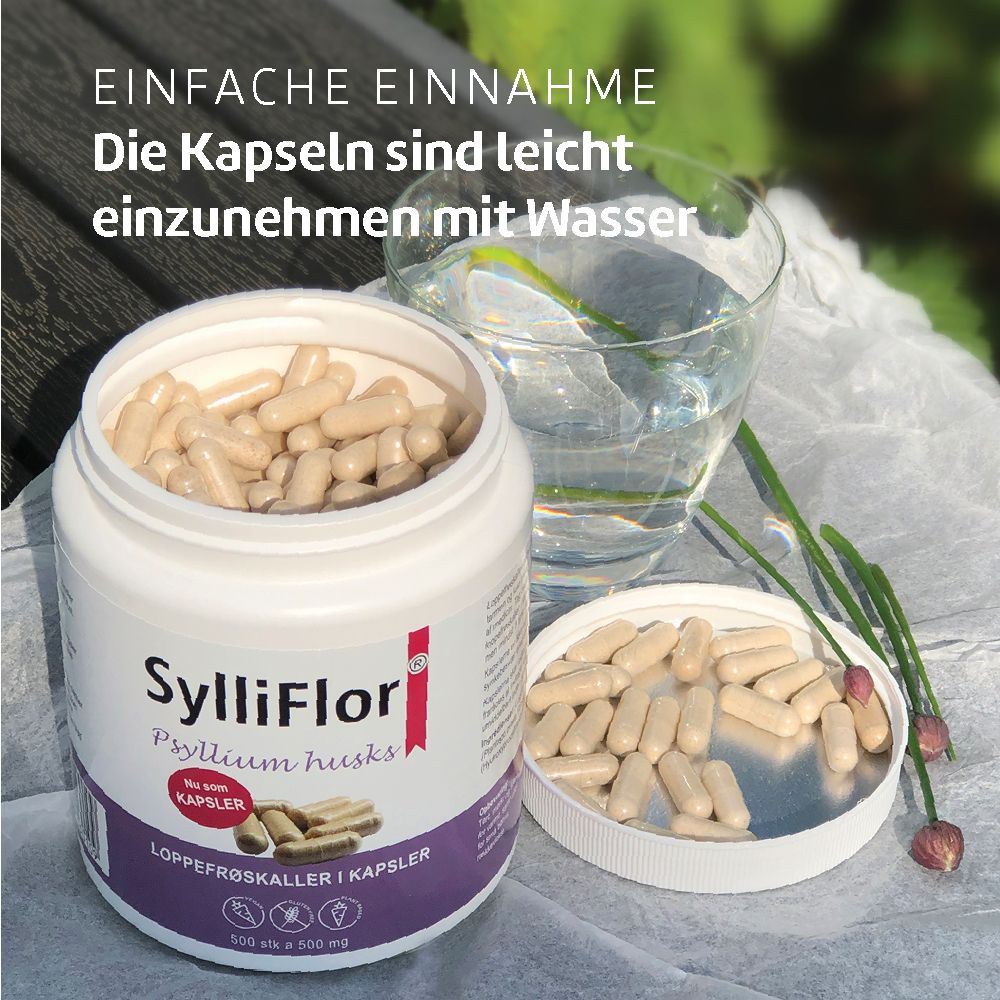 Behälter mit geöffnetem Deckel und Kapseln. Daneben ein Glas Wasser. Aufschrift: SylliFlor Psyllium husks Kapsler.