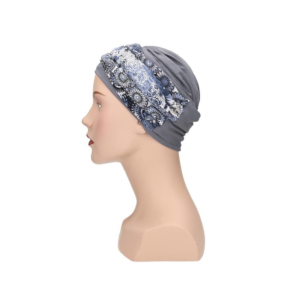 Grauer Turban mit floralem Muster. Auf einem Mannequin präsentiert. Seitenansicht.