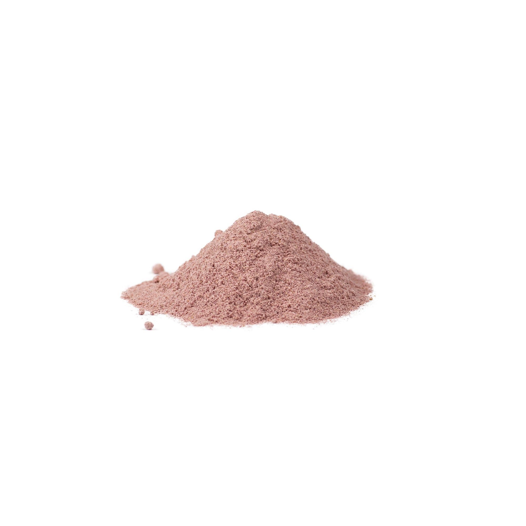 Haufen rosa Pulver auf weißem Hintergrund. Keine Verpackung sichtbar.