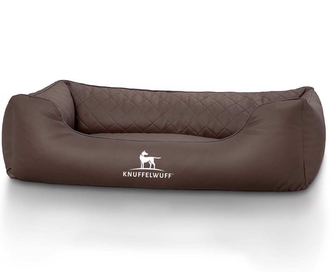 Braunes orthopädisches Hundebett mit gesteppter Oberfläche. Das Logo "Knuffelwuff" ist sichtbar. Abgerundete Form mit erhöhten Seiten.