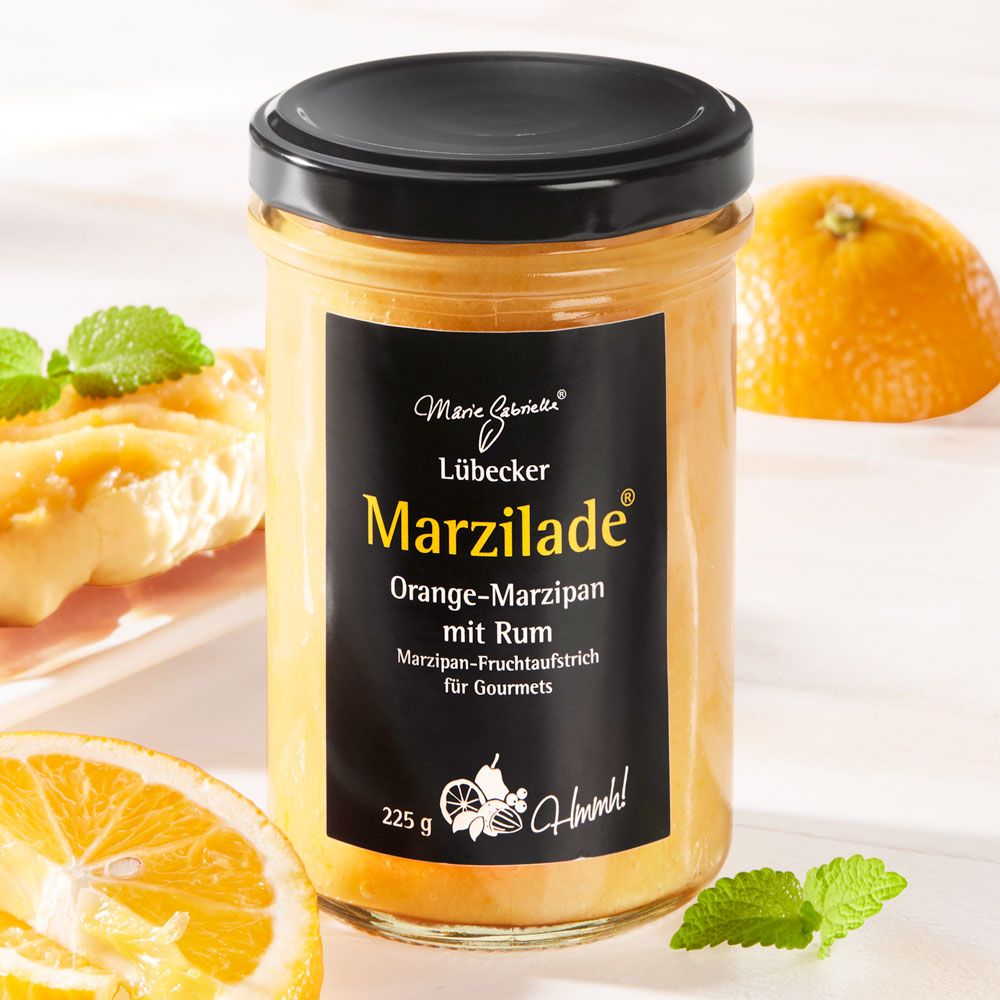Glas mit schwarzem Deckel und Etikett. Aufschrift: Marzilade Orange-Marzipan mit Rum. 225g. Mit Orange und Minze.
