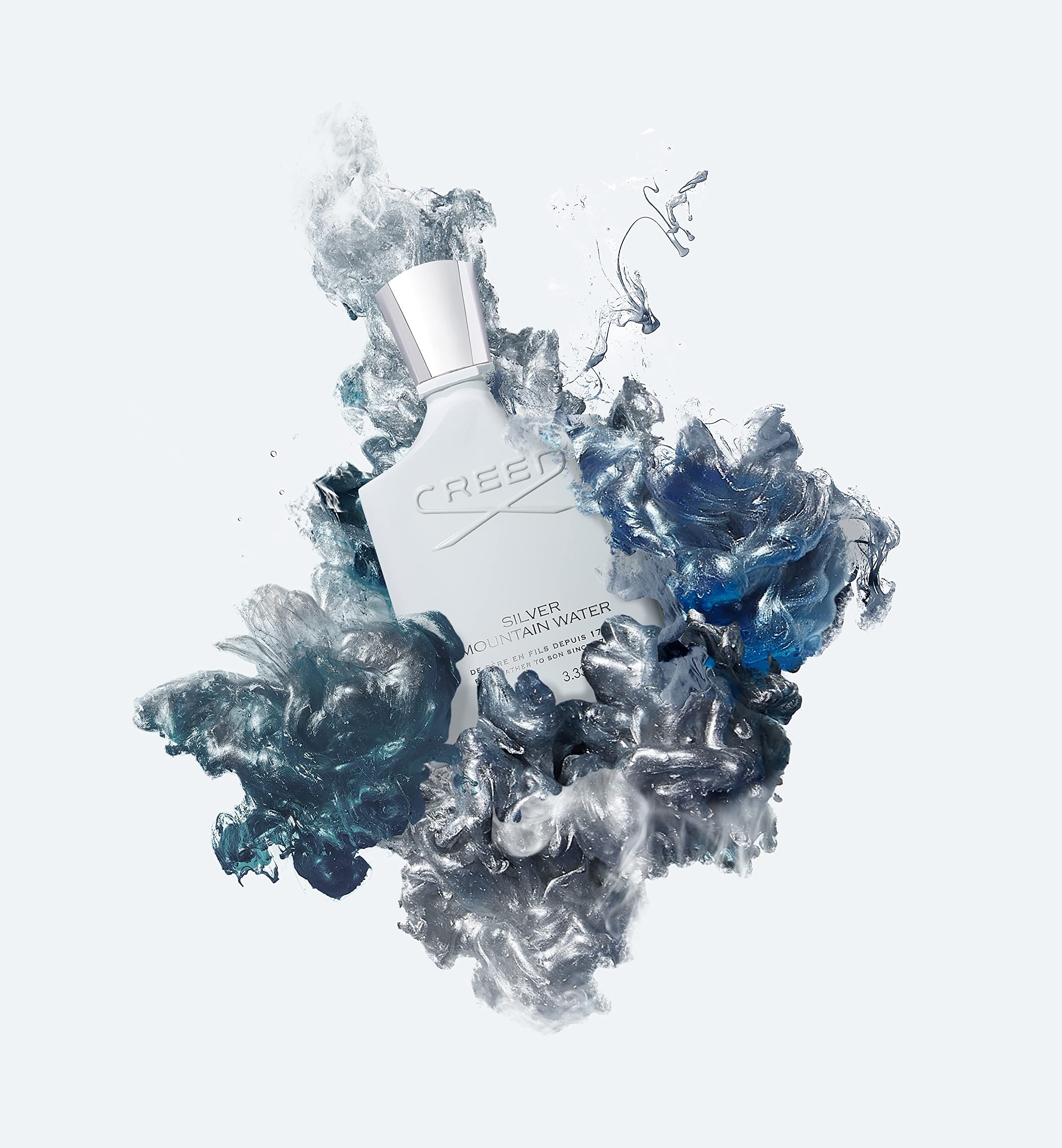 Weiße Parfumflasche in blauen und silbernen Farbwolken. Aufschrift: Creed Silver Mountain Water.